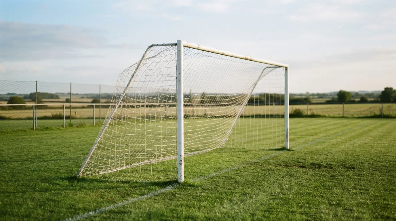 Ein Fussballtor mit locker hängendem Netz auf einem Trainingsplatz, das sich leicht im Wind bewegt.