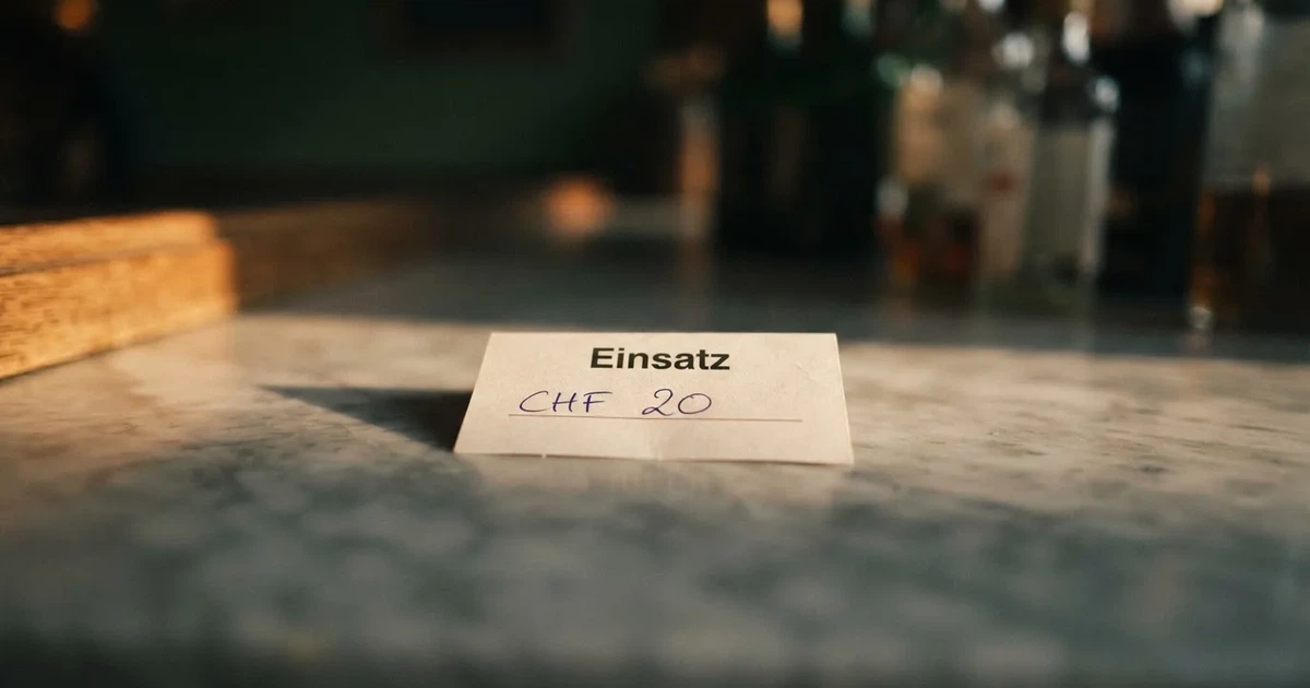 Eine einzelne Münze liegt auf einer glatten Marmorplatte im Seitenlicht, der Hintergrund ist weich unscharf.